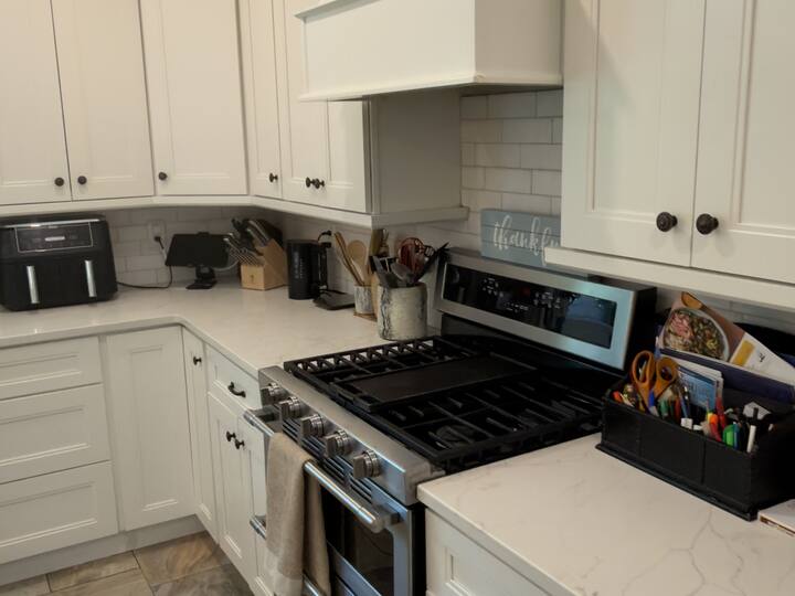 Kitchen with white cabinets and range cleaned by AJ Premium Cleaners
